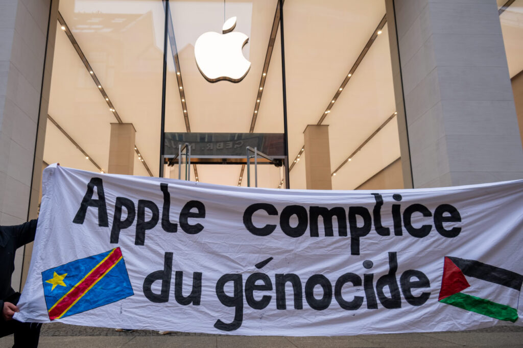 Ein Transparent mit der Aufschrift "Apple complice du genocide" vor einem Apple Geschäft.